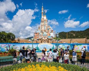 Visitors take photos in front of the Castle of Magical Dreams at Hong Kong's Disneyland on June 18, 2020, after the theme park officially reopened following nearly five months of closure in a fresh boost for a city that has largely managed to defeat the COVID-19 coronavirus. (Photo by Anthony WALLACE / AFP) (Photo by ANTHONY WALLACE/AFP via Getty Images)